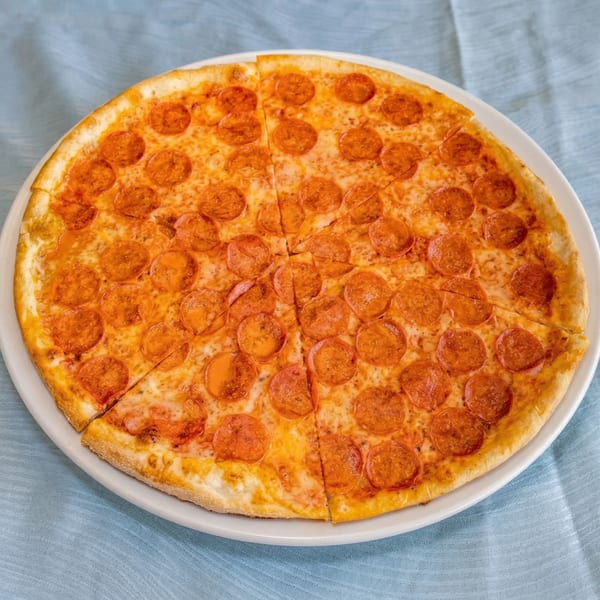A whole pepperoni pizza from PIZZA UNO INC, cut into eight slices on a white plate.
